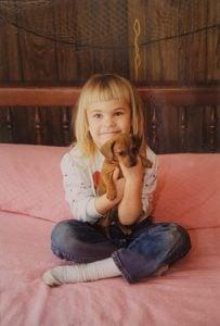 Stephanie holding a dachshund puppy, showcasing her passion for breeding and love for dogs